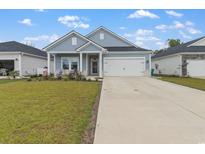 Charming single-story home with light blue siding, well-manicured lawn, and an attached two-car garage at 723 Cypress Preserve Circle, Longs, SC 29568