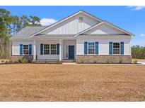 Charming single-story home with a brick-accented facade, bright blue shutters, and a well-manicured lawn at 6025 Flossie Rd., Conway, SC 29527