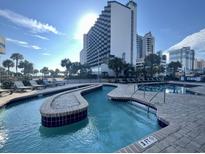 Exterior shot of a relaxing 3-foot deep lazy river at Bluewater Resort with the resort building in the background at 2001 S Ocean Blvd. # 820, Myrtle Beach, SC 29577
