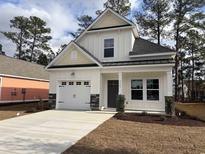 Charming two-story home with a white exterior, stone accents, and an attached garage at 3125 Tiger Tail Rd., Conway, SC 29526