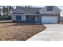 Charming single-Gathering home with stone accents, attached garage, and freshly poured driveway at 1581 Highway 701 South, Loris, SC 29569