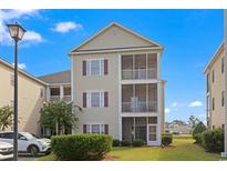 Three story condo with screened in patios, neutral colored siding and maroon shutters on a sunny day at 2090 Cross Gate Blvd. # 205, Surfside Beach, SC 29575