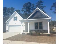 Charming single-story home featuring a two-car garage, white siding, and attractive stone accents at 1209 Nw Calabash Station Blvd., Calabash, NC 28467