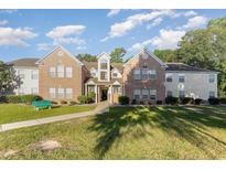 Inviting exterior of a brick and siding two-story building, complete with a well-maintained lawn and landscaping at 4390 Daphne Ln. # H, Murrells Inlet, SC 29576