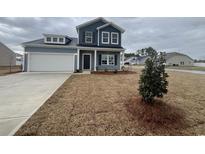 Charming two-story home with blue siding, white trim, and a well-manicured front yard at 710 Nw Night Lotus Dr., Calabash, SC 28467