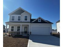 Two-story house with gray and white siding, a two-car garage, and landscaping at 203 Portofino Dr., Myrtle Beach, SC 29579