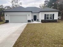Charming single-Gathering home featuring white siding, a two-car garage, and a well-maintained lawn at 348 Jay St., Murrells Inlet, SC 29576