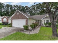 Charming home with a well-manicured front yard, brick accents, and attached two-car garage and driveway at 376 Mckendree Ln., Myrtle Beach, SC 29579