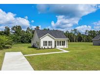 Charming single-story home featuring a well-manicured lawn, a concrete driveway, and a covered front porch at 1234 St. John Rd., Galivants Ferry, SC 29544