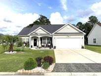 Charming single-story home with a well-manicured front yard and attached two-car garage at 205 Maple Oak Dr., Conway, SC 29526
