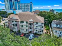 Beautiful building exterior with parking, balconies, and mature trees near the ocean at 2805 N Ocean Blvd. # 214, Myrtle Beach, SC 29577