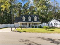 Attractive two-story house with a spacious lawn and a white fence at 118 Sly Fox Trail, Myrtle Beach, SC 29588