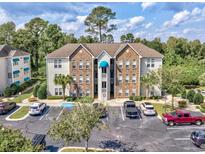 Attractive condo building with stone accents, a parking lot, and mature landscaping at 9772 Leyland Dr. # 9772-9, Myrtle Beach, SC 29572