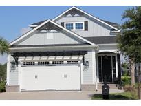 Charming two-story home featuring a white garage door with a black pergola and light gray siding at 981 Crystal Waterway Dr., Myrtle Beach, SC 29579