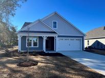 New construction home with gray siding, white trim, and a two-car garage at 905 Anemone Ct Nw, Calabash, NC 28467