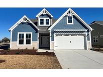 Two-story home with blue siding, white trim, and a two-car garage at 920 Anemone Ct Nw, Calabash, NC 28467