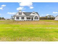 Charming single-Gathering home boasting a symmetrical facade, black shutters, and a spacious green lawn at 3538 Good Luck Rd., Aynor, SC 29511