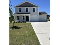 Charming two-story home with a two-car garage and well-manicured front lawn and large concrete driveway at 64 Cape Point Dr., Conway, SC 29527