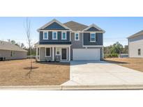 Charming two-story home with a well-manicured lawn and a two-car garage, offering a welcoming curb appeal at 68 Cape Point Dr., Conway, SC 29527