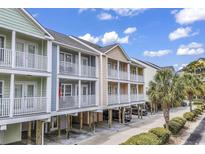 Colorful multi-level beach homes with balconies, ground-level parking, and lush tropical landscaping at 209 N Hillside Dr. N # 104, North Myrtle Beach, SC 29582