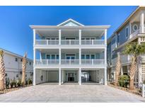 Three-story coastal home with pale blue siding, white trim, and multiple levels of covered balconies at 5203 Ocean Blvd. N, North Myrtle Beach, SC 29582