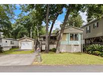 Charming home with a detached garage, driveway, and a well-maintained lawn, enhanced by a pink flamingo statue at 6001-Mh107 S Kings Hwy., Myrtle Beach, SC 29575