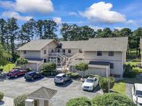 An inviting exterior view of the condo complex with lush landscaping, ample parking, and a charming stairwell to upper units at 3015 Old Bryan Dr. # 13-1, Myrtle Beach, SC 29577
