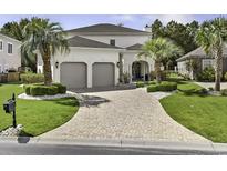 Beautiful home with a paved driveway, manicured lawn, and lush landscaping with palm trees and shrubbery at 616 Edgecreek Dr., Myrtle Beach, SC 29579