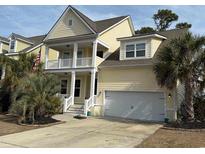 Two-story yellow house with white trim, balcony, and attached garage at 821 Falkirk St., Myrtle Beach, SC 29579