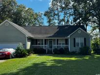 Gray house with a covered porch, attached garage, and well-maintained lawn at 78 Joys Pl., Andrews, SC 29510