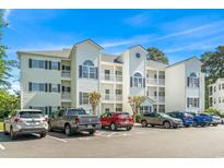 White two-story condo building with ample parking at 1525 Lanterns Rest Rd. # 103, Myrtle Beach, SC 29579