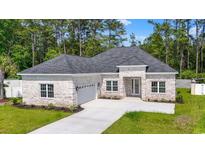 Charming brick home featuring a well-manicured lawn and attached two-car garage at 205 Waterfall Circle, Little River, SC 29566