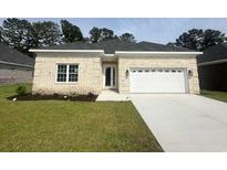 Charming single-story home boasts a brick facade, well-manicured lawn, and an attached two-car garage at 293 Waterfall Circle, Little River, SC 29566