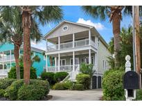 Charming two-story home with double front porches surrounded by lush landscaping and palm trees at 5407 N Ocean Blvd., Myrtle Beach, SC 29577