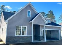 Charming home showcasing stone accents, siding, and an attached two-car garage in a picturesque neighborhood at 650 Timber Creek Dr., Loris, SC 29569
