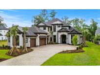Stunning luxury home with a three-car garage, detailed trim, and a meticulously manicured lawn at 372 Chamberlin Rd., Myrtle Beach, SC 29588
