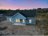 New construction home, aerial view showcasing gray siding and covered porch at 7915 E Highway 19, Loris, SC 29569