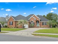 Charming brick home featuring a well-manicured lawn and mature palm trees creating curb appeal at 9048 Abingdon Dr., Myrtle Beach, SC 29579