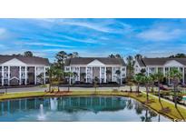 Beautiful condo complex with lush landscaping and a tranquil pond featuring a fountain at 106 Birch N Coppice Dr. # 2, Surfside Beach, SC 29575