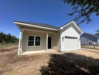 Charming exterior elevation showcasing neutral siding, white trim, and an attached garage on a sunny day at 7913 E Highway 19, Loris, SC 29569