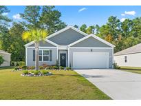 Charming single-Gathering home with gray siding, a well-maintained lawn, and a two-car garage at 149 Harmony Ln., Myrtle Beach, SC 29588