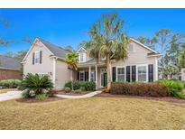 Charming home showcasing a landscaped yard with mature palm trees and a welcoming front porch at 621 Elgin Ct., Myrtle Beach, SC 29579