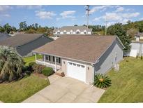 Tan house with white garage door and landscaping at 9557 Sullivan Dr., Murrells Inlet, SC 29576