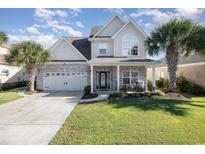 Charming two-story home with a brick facade, landscaped yard, and mature palm trees at 1002 Summers Pl., North Myrtle Beach, SC 29582