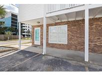 Brick condo with a white balcony overhead and parking in front in a beach community at 1502 Yaupon Dr. # A-1, Myrtle Beach, SC 29577