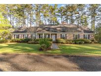 Charming brick ranch home with lush landscaping and a welcoming front porch at 2807 Graham Rd., Conway, SC 29526