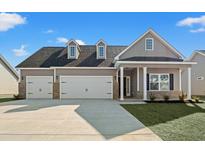 Two-story house with neutral siding, a double garage, and a covered porch at 315 Hayloft Circle, Conway, SC 29526