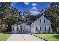 Charming home with a well-manicured lawn, inviting entrance, and a long driveway leading up to the attached garage at 323 Trestle Way, Conway, SC 29526