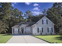 Charming single-Gathering home with well-manicured lawn, large trees, and a gray driveway and exterior at 323 Trestle Way, Conway, SC 29526