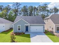 Charming single-story home with blue front door, green lawn and attached garage at 389 Sun Colony Blvd., Longs, SC 29568